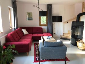 SmidaCASA SMIDA JAZZ的客厅设有红色的沙发和壁炉