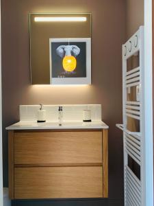 克莱蒙费朗Warm & Wood的浴室设有水槽,并画有橙色的画面