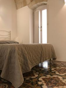 滨海波利尼亚诺卡萨住宿加早餐酒店的一间卧室配有一张床铺,床上有毯子