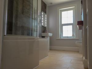 尚克林Carriers Cottage, Isle of Wight的带浴缸、水槽和窗户的浴室