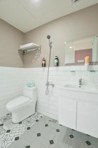 台中市喜鵲Magpie Hostel的白色的浴室设有卫生间和水槽。