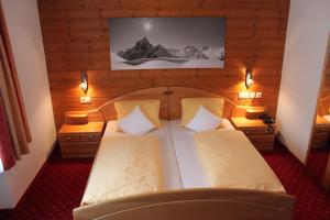 圣安东阿尔贝格Hotel Garni Dorfblick的一间卧室配有一张大床和两个枕头