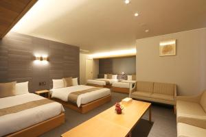 名古屋GRAND BASE Nagoya Ekinishi的酒店客房,设有两张床和一张沙发