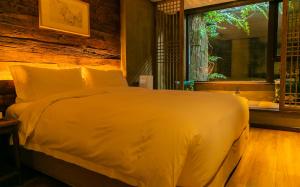 武当山武当山太和紫隐酒店的卧室配有一张大白色床和窗户
