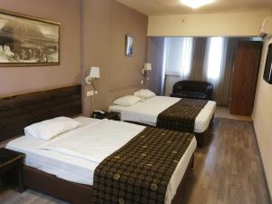 提比里亚阿斯托利亚加利利酒店 的酒店客房,配有两张床和椅子