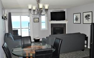 林肯市Starfish Manor Oceanfront Hotel的客厅配有桌椅和电视。