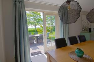 曲马勒姆Friesland Villa & Blick auf den Horizont的一间带桌子和滑动玻璃门的用餐室