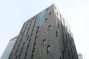 首尔明洞托马斯酒店的一座高大的灰色建筑,上面有窗户
