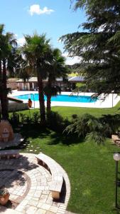 孔韦尔萨诺B&B Il Mulino del Monastero的一个带游泳池和棕榈树的度假村