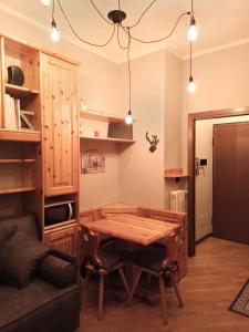 蓬泰迪莱尼奥Appartamento GARDEN Ponte di Legno的客房设有木桌和沙发。
