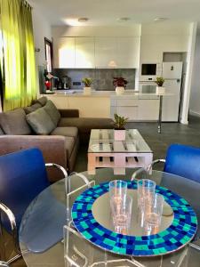 艾姆布里亚布拉瓦Casa Montgri的客厅配有玻璃桌和蓝色椅子