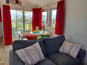MichaelisdorfOstermade Klintdoerp 110的带沙发和红色窗帘的客厅