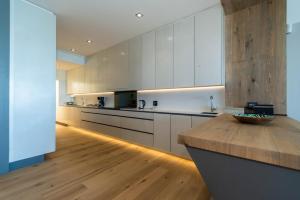 赫曼努斯Bayview 303的厨房配有白色橱柜和木制台面