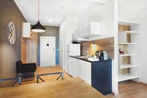 齐莱涅克Apartamenty Zieleniec的厨房配有白色橱柜和黑色台面