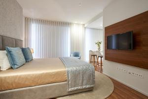 波尔图Signature Apartments Santa Catarina的配有一张床和一台平面电视的酒店客房