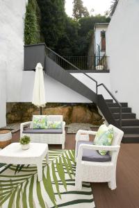 波尔图Signature Apartments Santa Catarina的庭院设有两把椅子、一张桌子和楼梯
