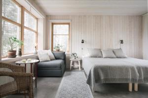 TåtorpSTF Tåtorp Cafe & Logi Göta Kanal的一间卧室配有一张床、一张沙发和窗户。