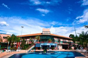 阿瓜斯迪林多亚奥斯卡生态度假酒店的一座大型建筑,前面设有一个游泳池