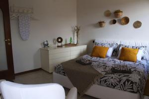 切尔诺比奥Casa all'era的一间卧室配有一张带黄色枕头和椅子的床