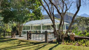 伊泰帕瓦Quinta da Paz Resort的花园中的温室,设有木栅栏