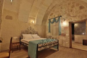 格雷梅Jacob's Cave Suites - Cappadocia的卧室配有一张石墙床