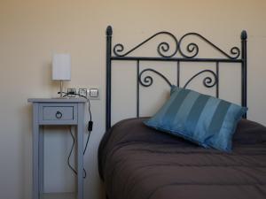 塞埃欣Casa Rural Ortega Rubio的一张带蓝色枕头和边桌的床