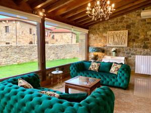 SaroAkla Hotel Suites Valles Pasiegos的客厅设有蓝色的沙发和石墙