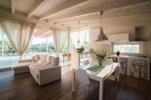 阿尔贝罗贝洛Villa Charming Trulli的厨房以及带桌子和沙发的客厅。