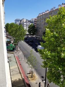 巴黎Hôtel Tingis的享有树木和建筑的城市街道景色