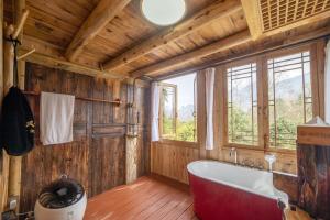 张家界Forest Glass inn的一间带大浴缸和窗户的浴室