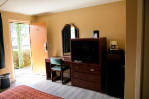 温泉城温泉城国王汽车旅馆的一间卧室配有带电视和镜子的梳妆台