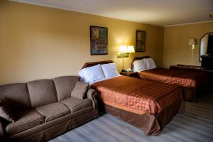 温泉城温泉城国王汽车旅馆的酒店客房,设有两张床和一张沙发