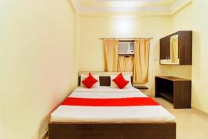 Mughal SarāiHotel Station View Mughalsarai by ShriGo Hotels的一间卧室配有红色枕头的床