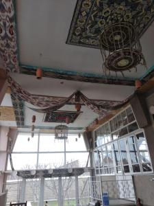 撒马尔罕Hotel Sartepo的客房设有窗户和带吊灯的天花板。
