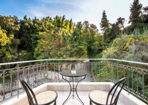 克里皮吉Marina's Elegance的阳台配有桌椅和树木。
