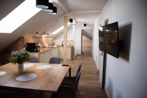 米科瓦伊基Apartamenty Ach To Tu的厨房以及带木桌和椅子的用餐室。