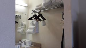坦帕坦帕华美达酒店的一间带镜子、衣架和毛巾的浴室