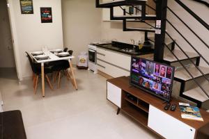马塞利努拉穆斯POUSADA GERMÂNICA的带电视的客厅和带桌子的厨房。