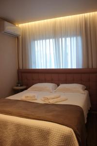 特雷齐蒂利亚斯Alpen Hospedagem的一间卧室配有一张大床和两条毛巾