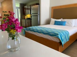 克拉伦代克迪维弗拉明戈海滩度假酒店的一间卧室,配有一张床,桌子上放着花瓶