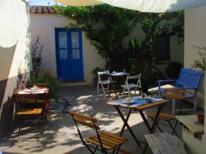 卡布拉斯Limolo Guesthouse的一个带桌椅的庭院和一扇蓝色的门