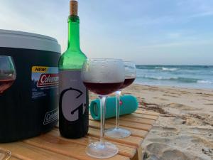 AricaguaCimarron Suites Playa Parguito的两杯葡萄酒,旁边放一瓶葡萄酒