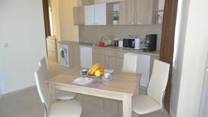 内塞伯尔阿克罗蒂里亚海滩公寓大楼 的厨房配有木桌和椅子,上面有水果