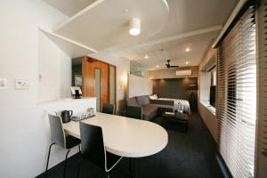 福冈ZONK HOTEL Nakasu的一间配备有白色桌椅和沙发的客房