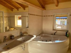 坦海姆Sonnleiten - Guggerhof - Villa Sonnenwies的一间带大浴缸和镜子的浴室