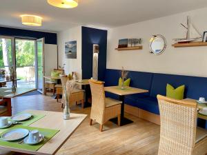 圣彼得奥尔丁Hotel Garni Dünennest的一间拥有蓝色墙壁和桌椅的用餐室