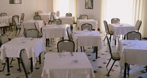 波利科罗赫拉克里亚酒店的一间设有桌椅和白色桌布的房间