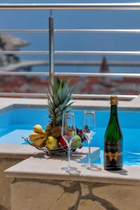 马卡尔斯卡Villa Sukara的一张桌子,上面放着两杯酒和一篮水果