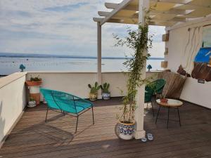 塔兰托B&B La Terrazza di NonnAnna的露台的甲板上摆放着椅子和植物