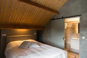 蒂尔特Abeellogies的一间卧室设有一张木天花板床。